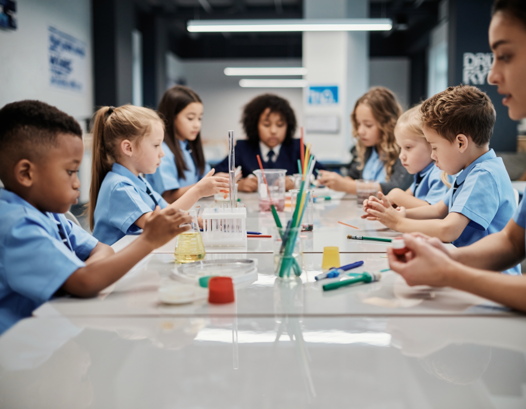 English-School-science-classroom-young-children-sat-at-a-table-with-science-beakers